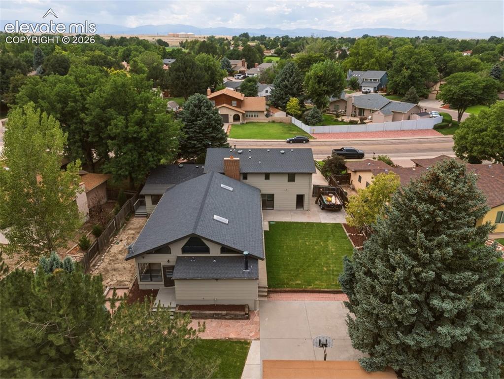 Image 30 of 32: Dual-level residence featuring a dark shingle roof, neutral-toned siding, a