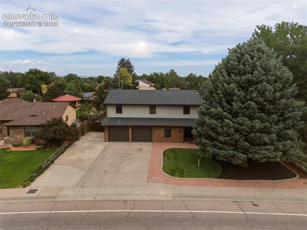 Image 31 of 32: Two-story residence featuring a two-car garage, brick facade detailing, and