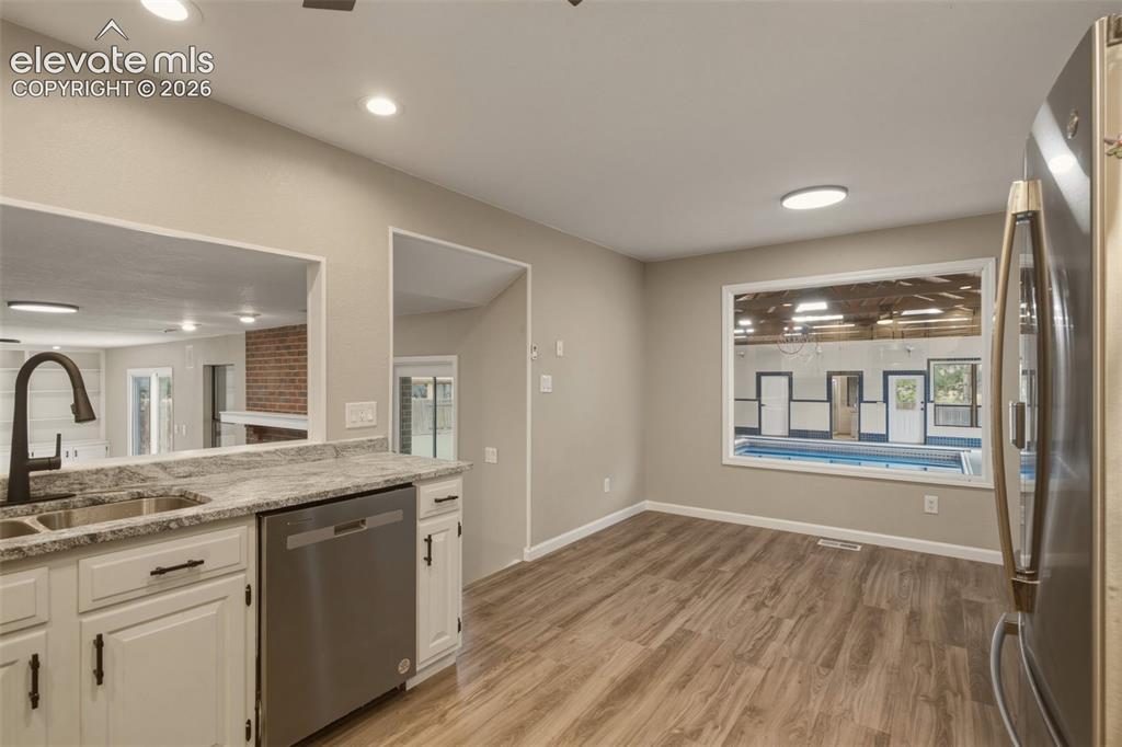 Image 5 of 32: Kitchen area featuring a dual basin sink, stainless steel appliances, wood-