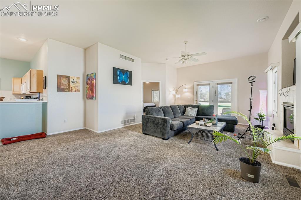 Image 4 of 11: Living area with carpet and a ceiling fan