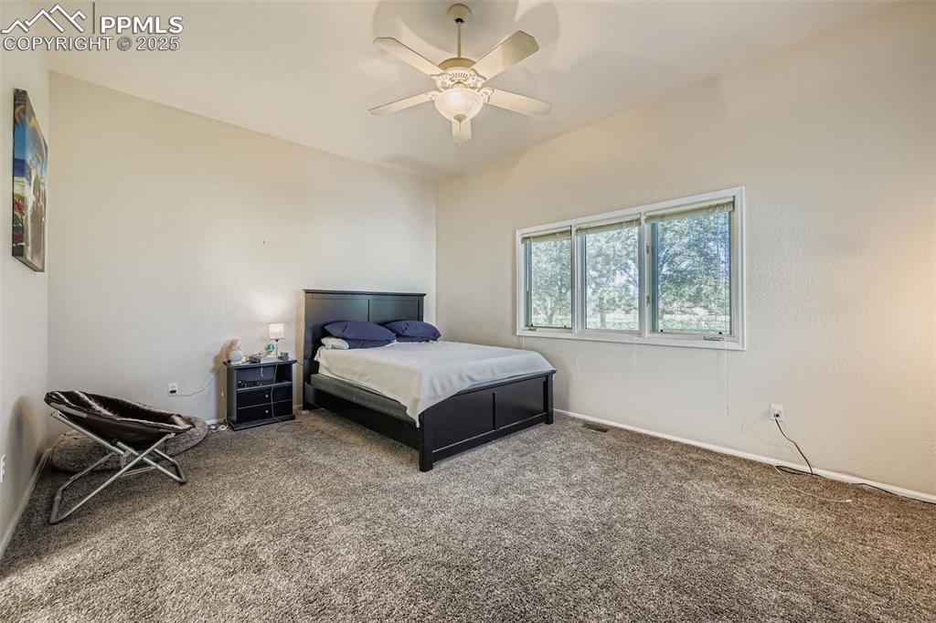 Image 7 of 11: Carpeted bedroom featuring a ceiling fan and baseboards