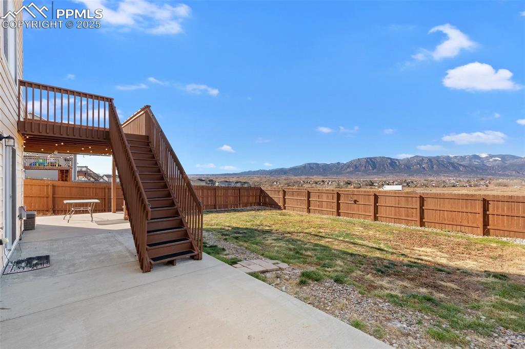 Image 11 of 42: Fenced backyard featuring a patio area, a mountain view, and stairs