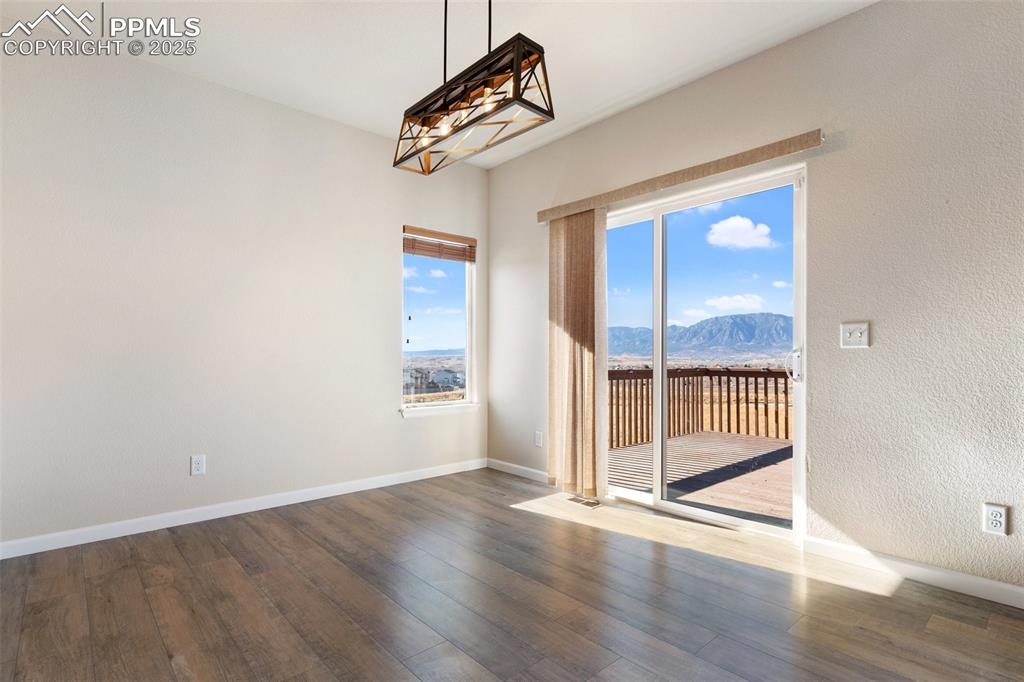 Image 13 of 42: Unfurnished room with a mountain view and wood-type flooring