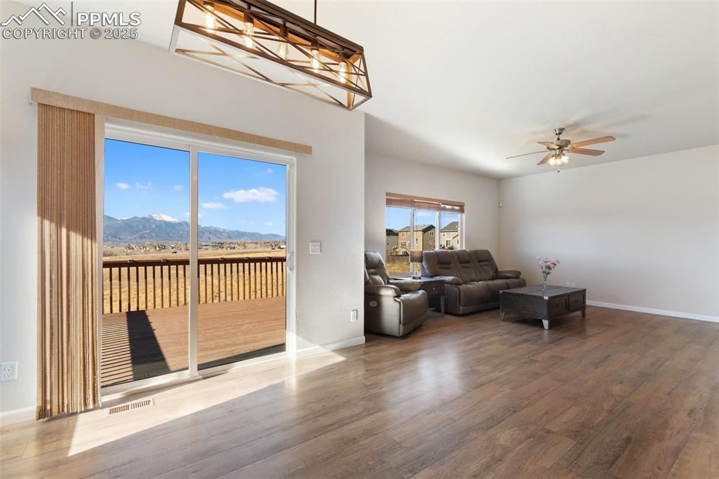 Image 14 of 42: Living room with wood finished floors, a mountain view, and a ceiling fan