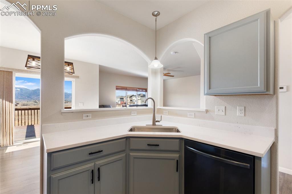 Image 16 of 42: Kitchen with gray cabinets, stainless steel dishwasher, a ceiling fan, hang