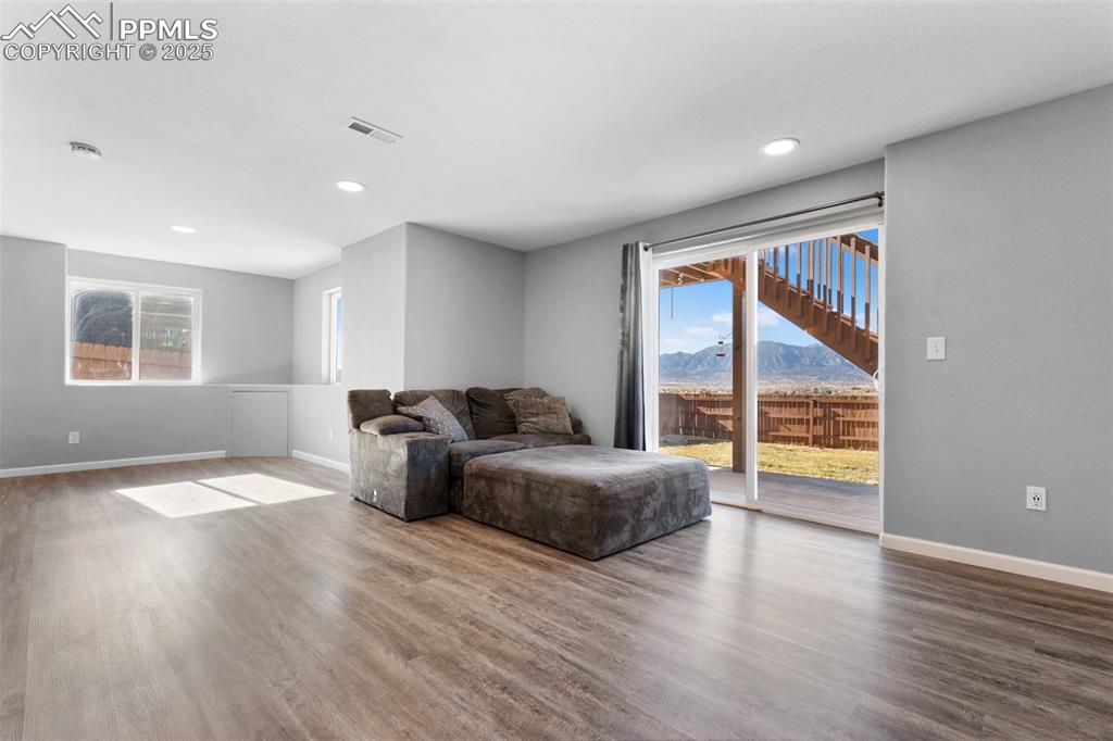 Image 19 of 42: Living area with a mountain view, wood finished floors, and recessed lighti