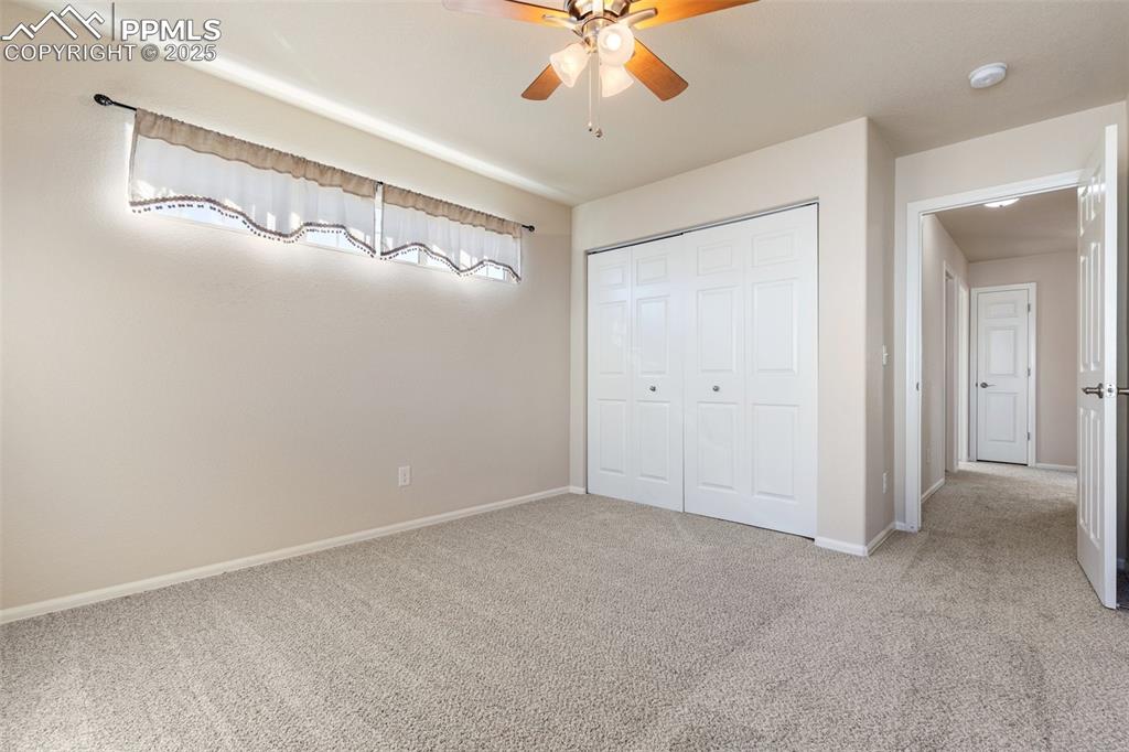 Image 39 of 42: Unfurnished bedroom featuring light carpet, a closet, and a ceiling fan