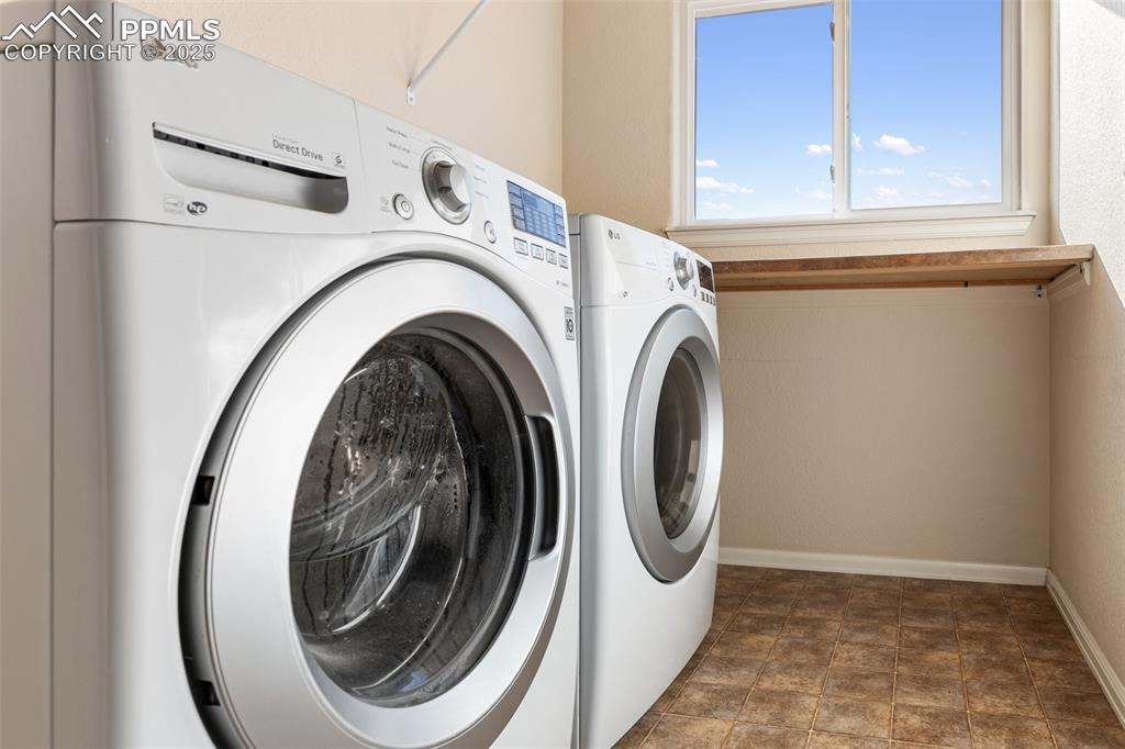 Image 41 of 42: Laundry room with separate washer and dryer and stone finish flooring