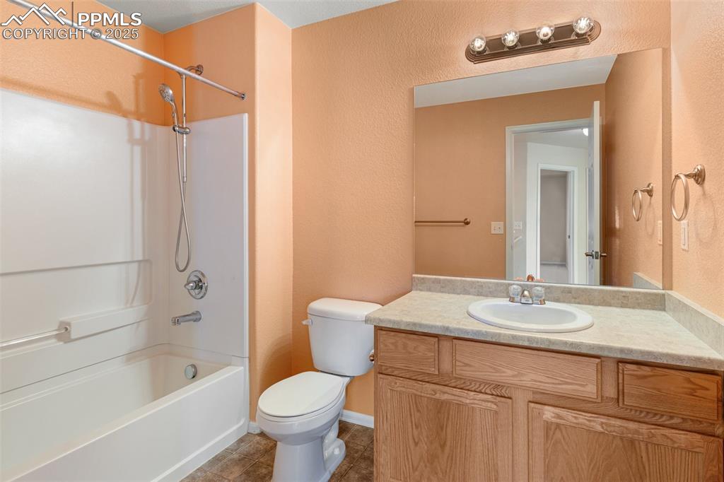 Image 42 of 42: Full bath with bathtub / shower combination, a textured wall, vanity, and d