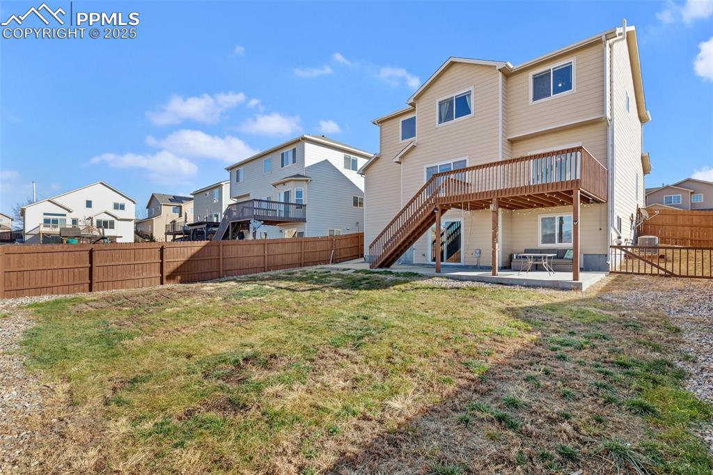 Image 7 of 42: Back of property featuring a patio area, a fenced backyard, a deck, a resid