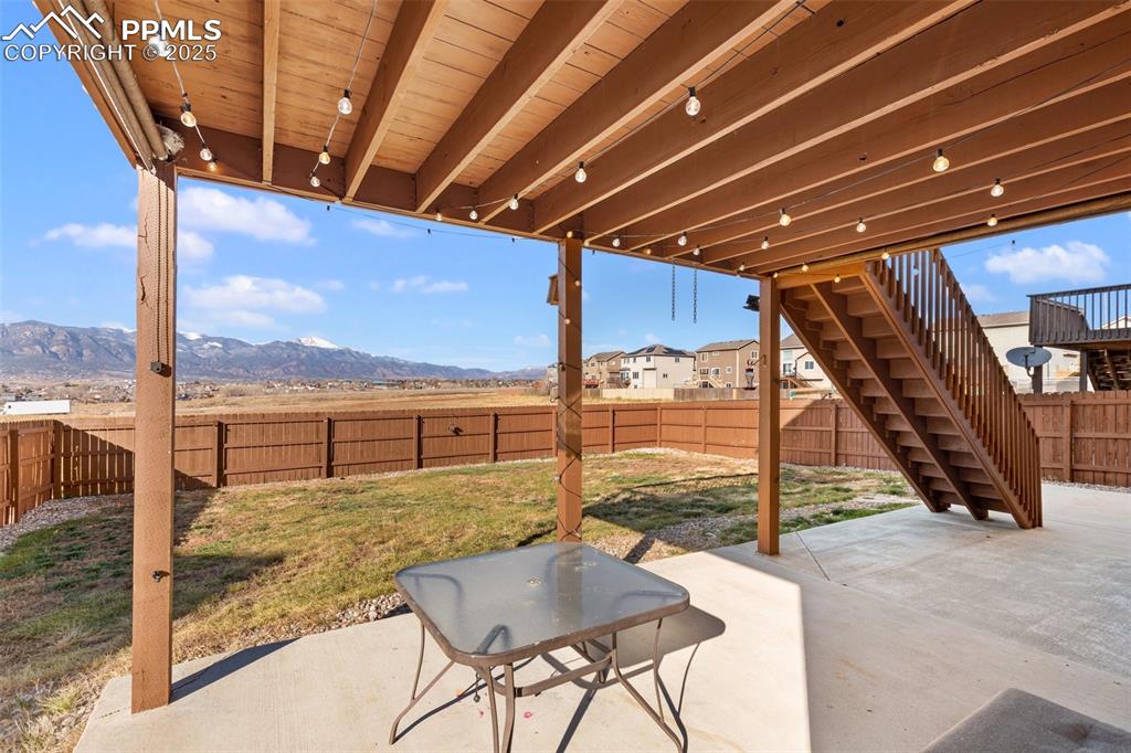 Image 8 of 42: Fenced backyard featuring stairs, a patio area, and a mountain view