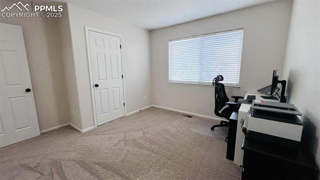Image 20 of 35: Carpeted home office with baseboards