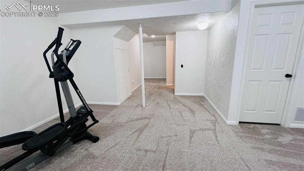 Image 25 of 35: Workout room featuring carpet floors, a textured wall, and a textured ceili