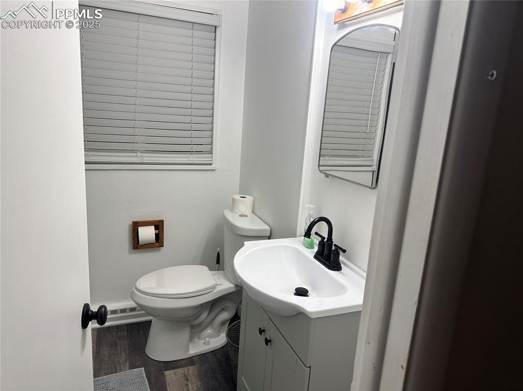 Image 10 of 12: Half bath featuring vanity and wood finished floors