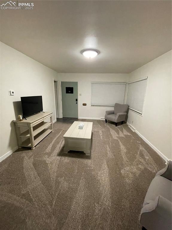 Image 4 of 12: Carpeted living room with baseboards