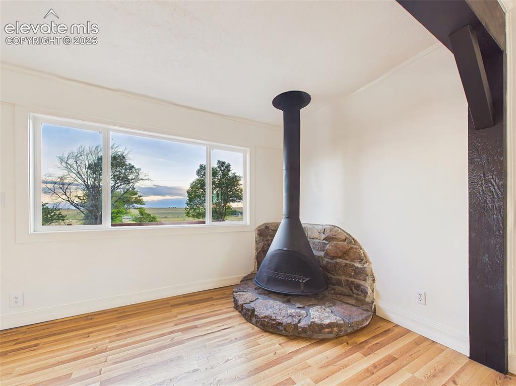 Image 13 of 50: Fireplace – Freestanding wood-burning fireplace set on a rustic stone heart