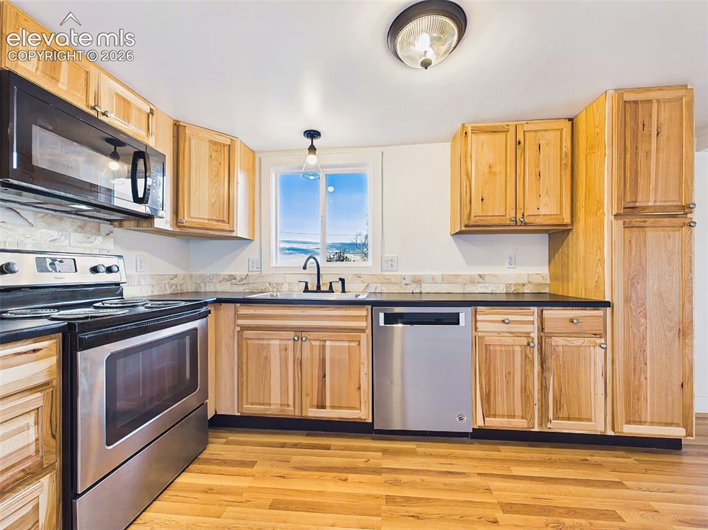 Image 19 of 50: Kitchen – Modern all-electric kitchen offers generous workspace, abundant c