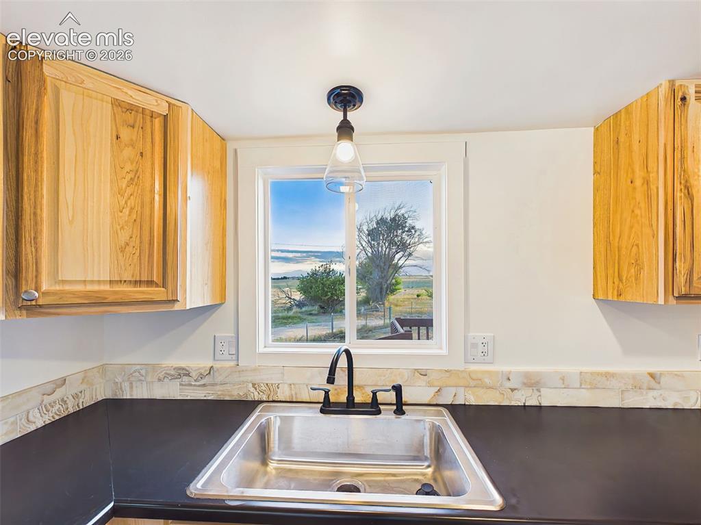 Image 20 of 50: Kitchen Sink View – Window above the sink brings in natural light and provi