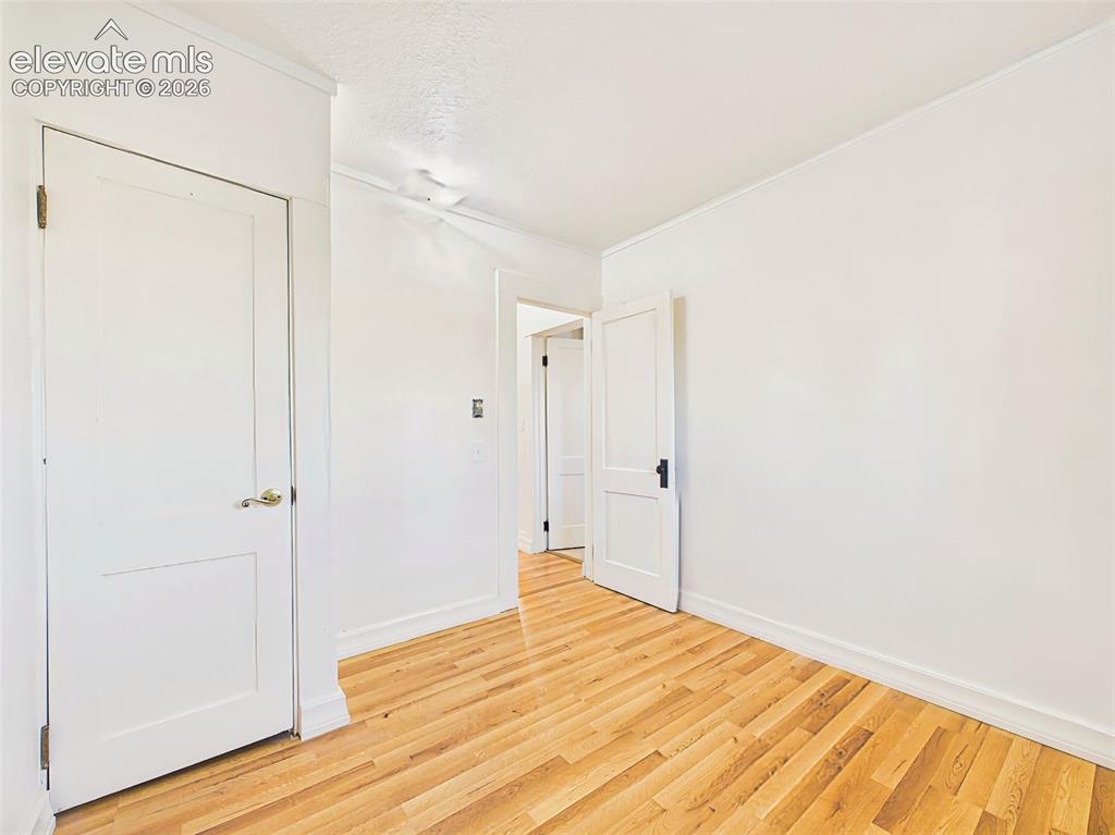 Image 33 of 50: Bedroom 3 – Bright bedroom features new flooring, neutral finishes, and a v