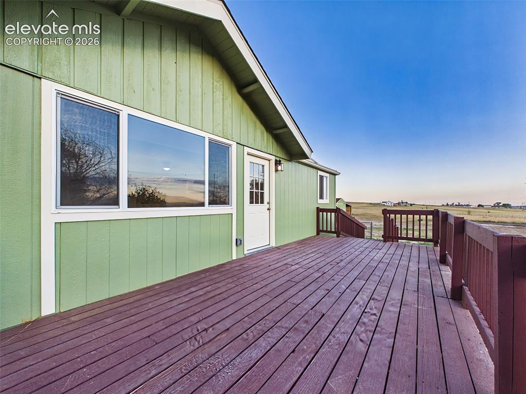 Image 40 of 50: Large wood deck extends the home