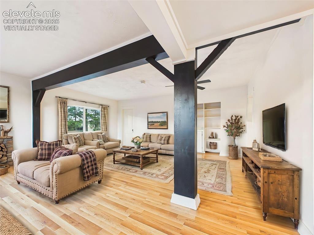 Image 5 of 50: (Virtually Staged) Living Room – Spacious living area with warm laminate fl