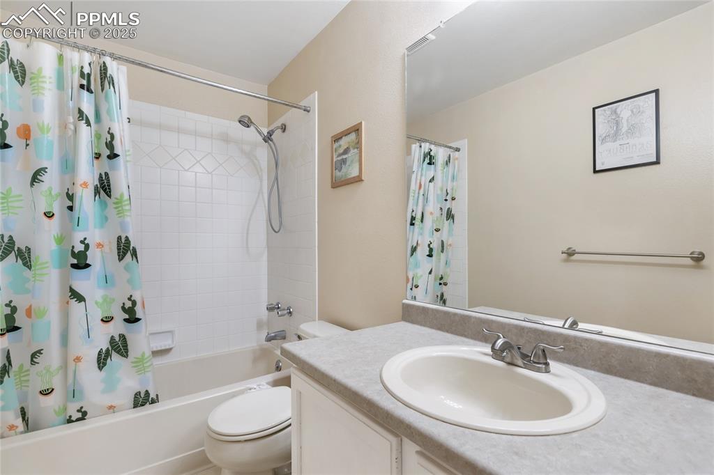 Image 16 of 28: Upper bathroom with shower / bathtub combination with curtain and vanity