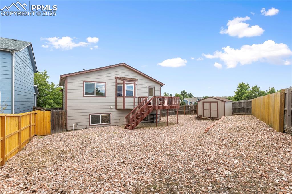 Image 22 of 28: Rear view of property featuring stairway, a fenced backyard, a deck, and a 