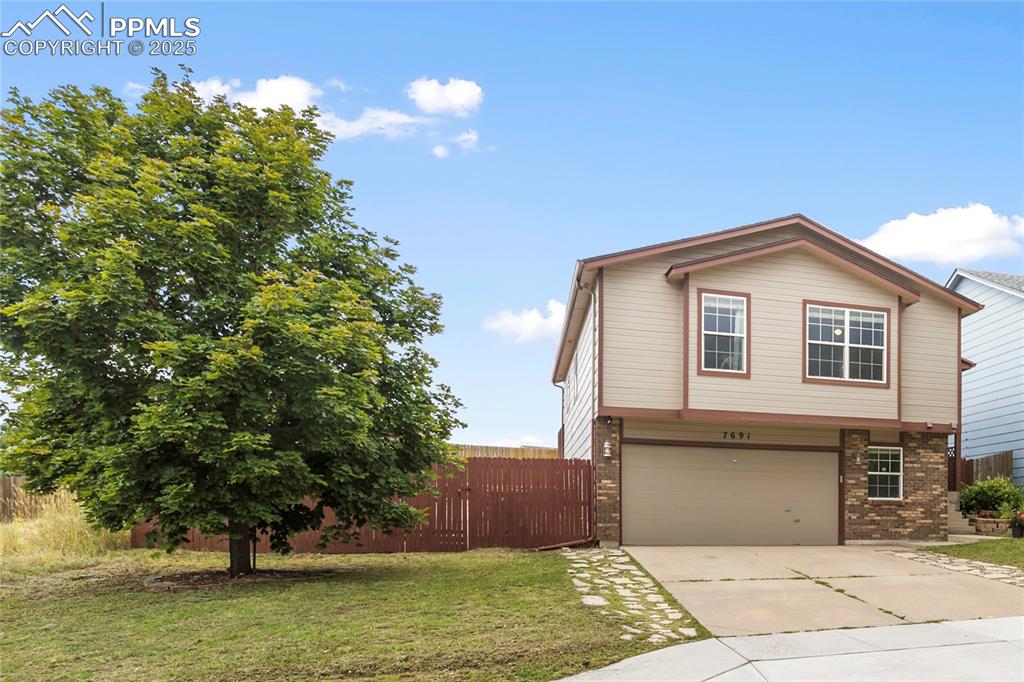 Image 25 of 28: View of front of house featuring concrete driveway, brick siding, and a gar