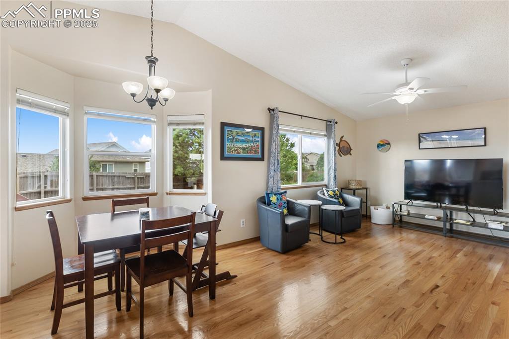 Image 4 of 28: Dining area with light wood finished floors, lofted ceiling, a chandelier, 