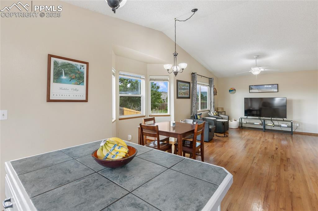 Image 7 of 28: Dining room with vaulted ceiling, light wood-style flooring, a chandelier, 
