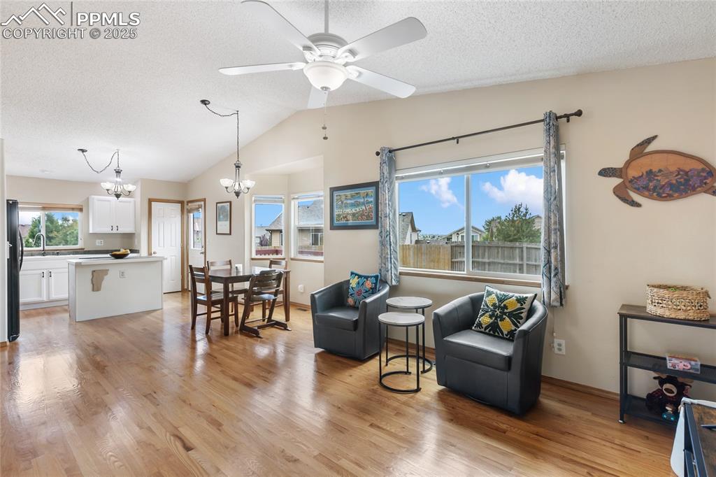 Image 8 of 28: Sitting room featuring light wood-style floors, a textured ceiling, lofted 