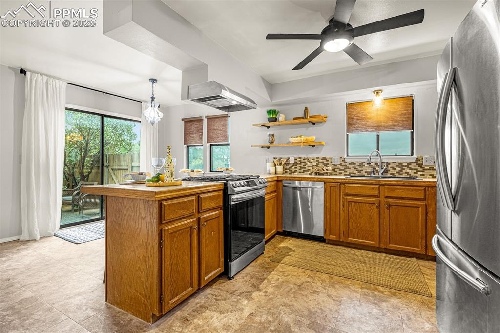 Image 7 of 19: Warm kitchen with new gas stove, stainless appliances and open shelving - e