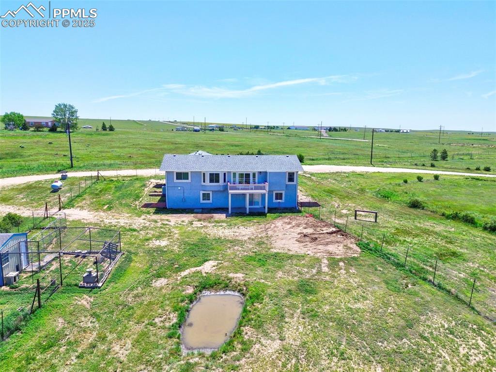 Image 31 of 50: Back Side of Home Looking EAST- Chicken Coop to the left with electric and