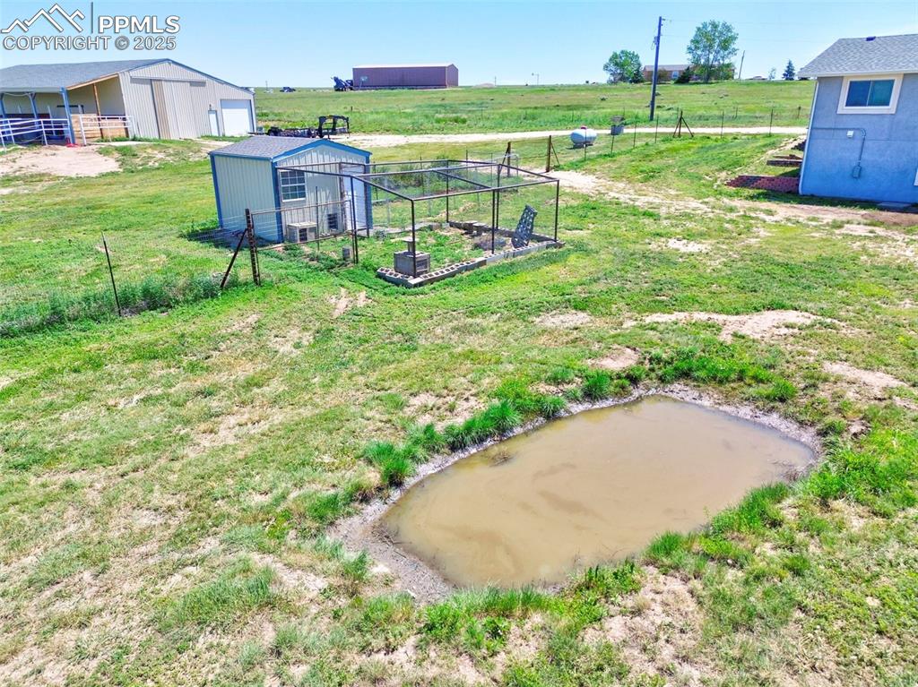 Image 33 of 50: Fenced in Back Yard Perfect for your Canine Friends/Goats. Run Off Pond fr