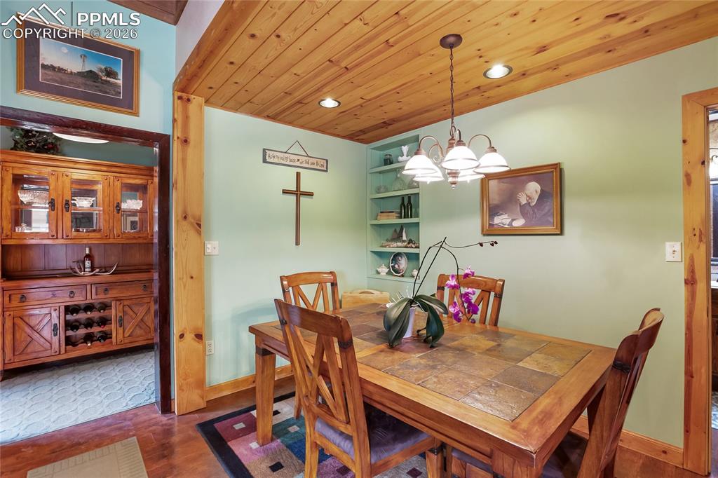 Image 11 of 39: The dining room with decorative storage shelves and wooden trim!