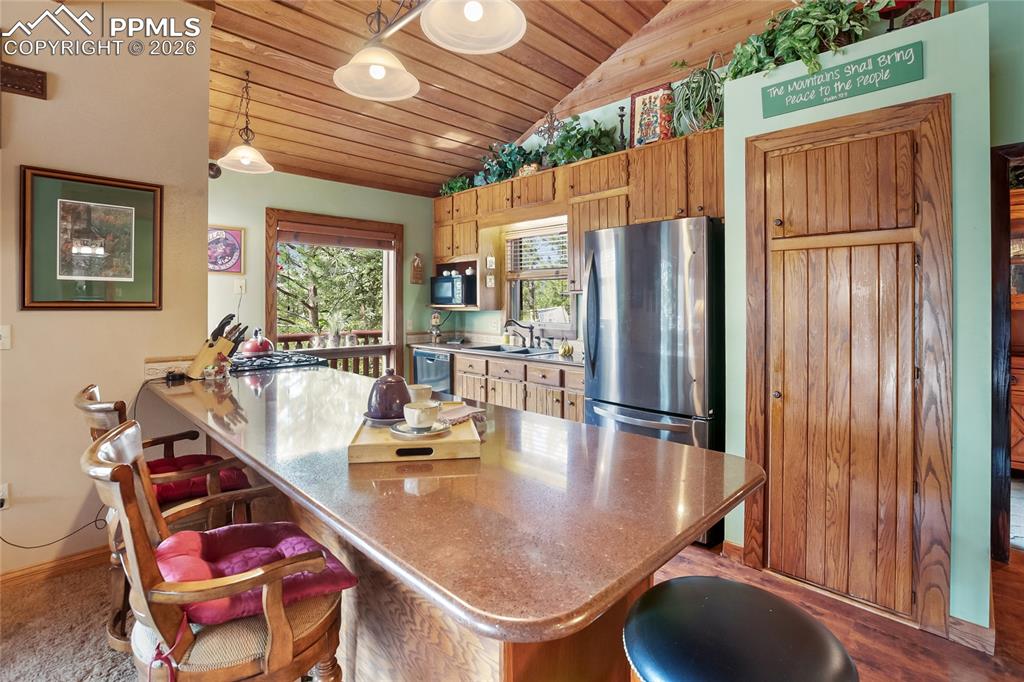 Image 7 of 39: Kitchen with a kitchen breakfast bar attached to the kitchen island, wood c