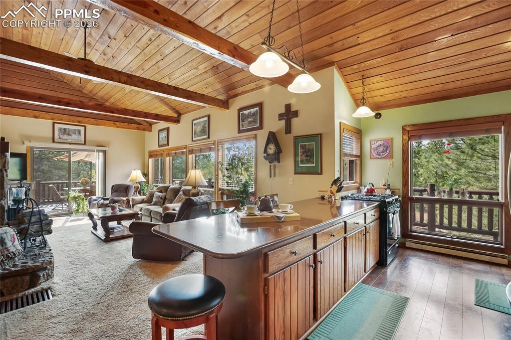 Image 9 of 39: Kitchen featuring wooden ceiling, black gas range oven with spider burners,