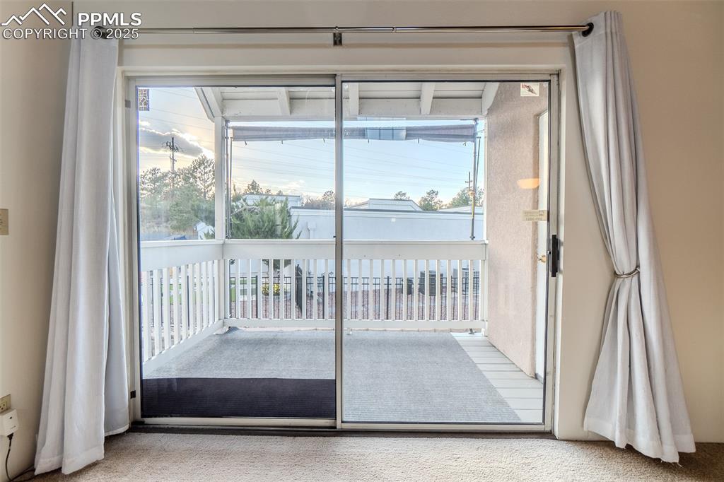 Image 14 of 27: Doorway featuring carpet flooring