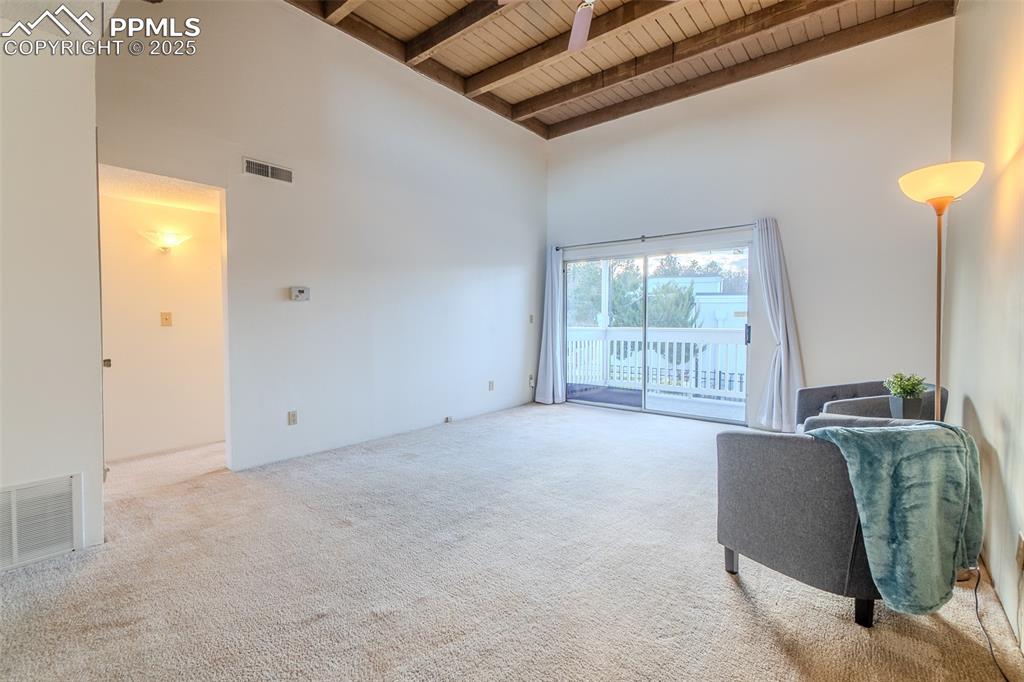 Image 15 of 27: Living room featuring a towering ceiling, carpet floors, and a wood ceiling
