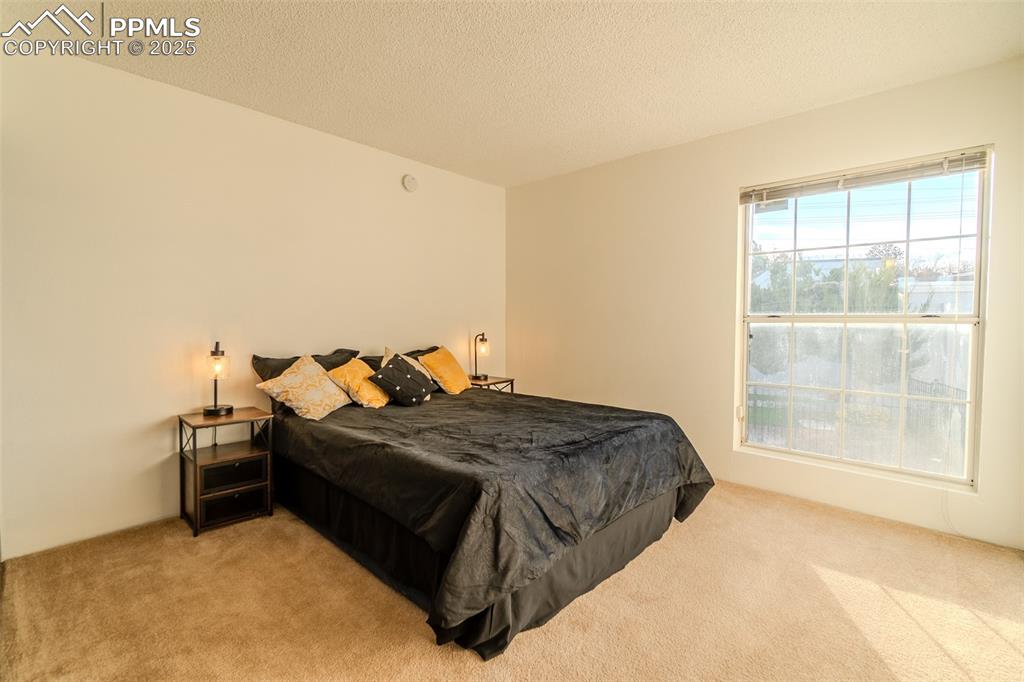 Image 18 of 27: Carpeted bedroom with a textured ceiling