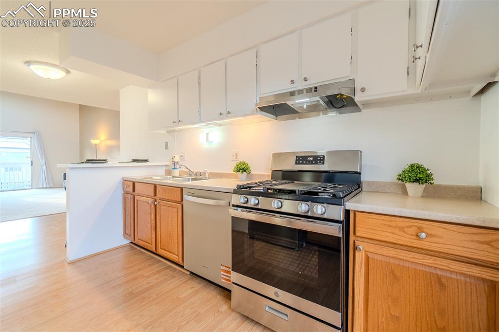 Image 5 of 27: Kitchen with stainless steel appliances, light countertops, under cabinet r