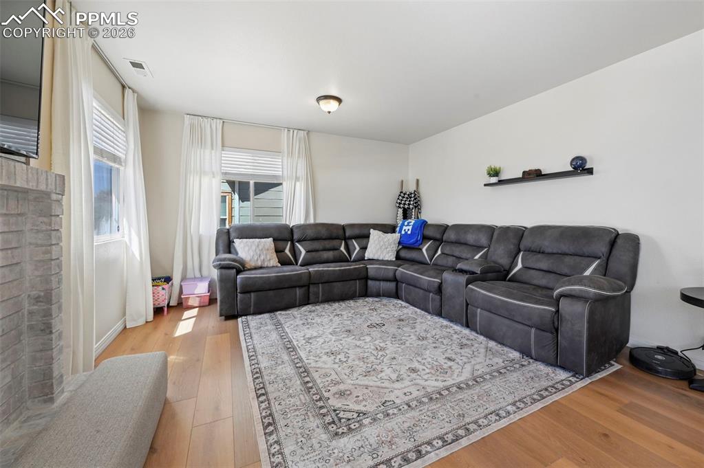 Image 15 of 45: The living room features white walls, and two windows with white blinds and