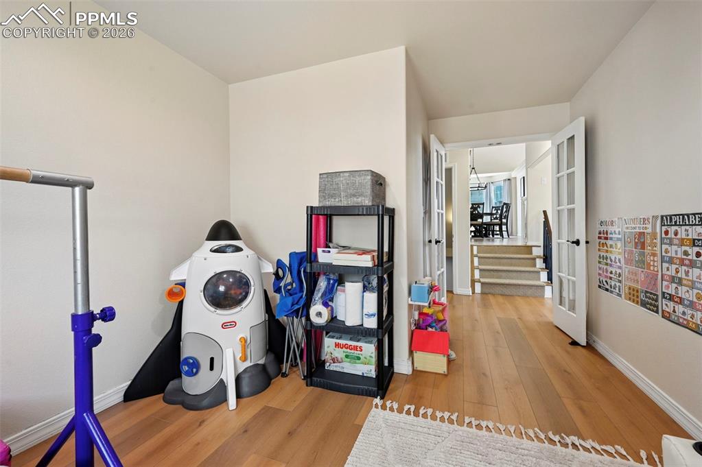 Image 18 of 45: An interior hallway with light-colored walls and wood laminate flooring