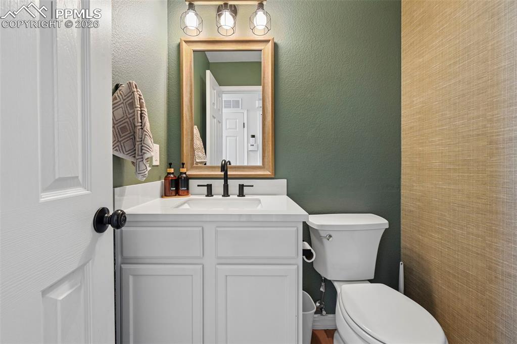 Image 19 of 45: This bathroom features a white vanity with a white countertop and a contemp