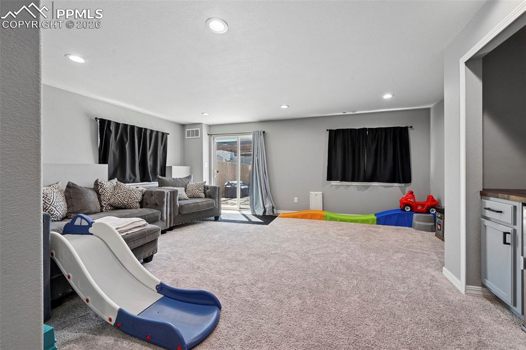 Image 20 of 45: This spacious room features neutral gray walls and light-colored carpeting 