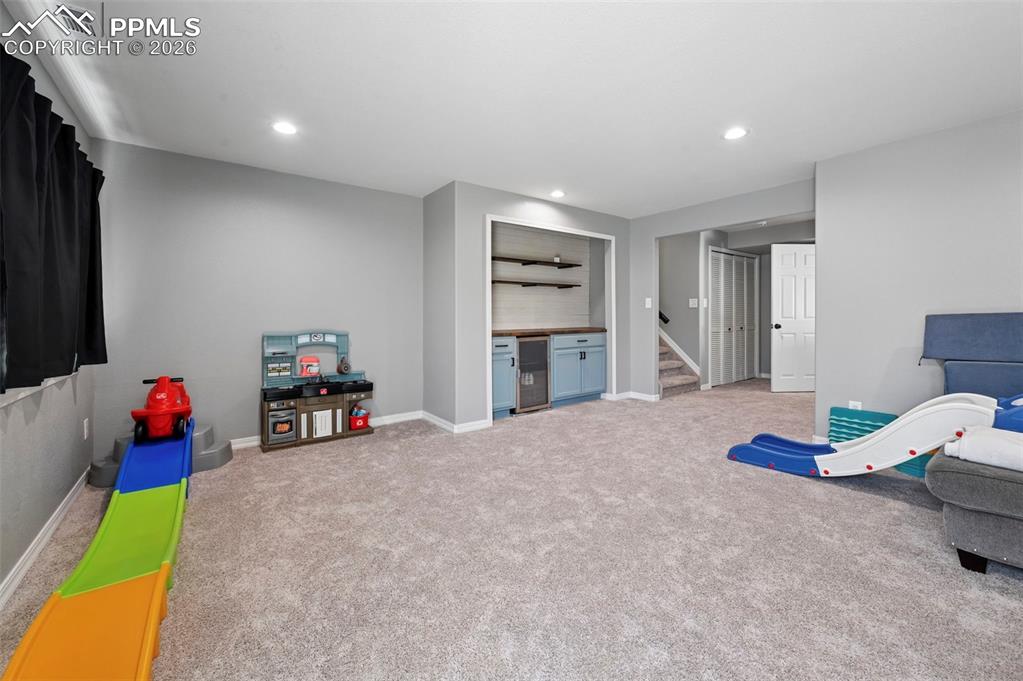 Image 21 of 45: This spacious room features light grey walls and carpeted flooring, creatin