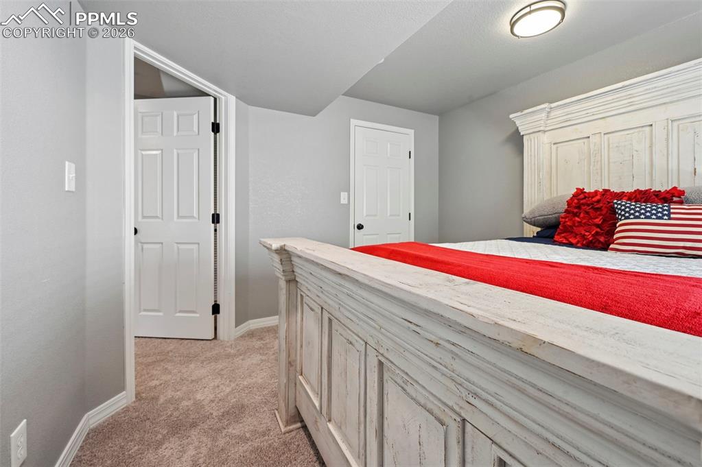 Image 24 of 45: This bedroom features light gray walls and plush carpeting