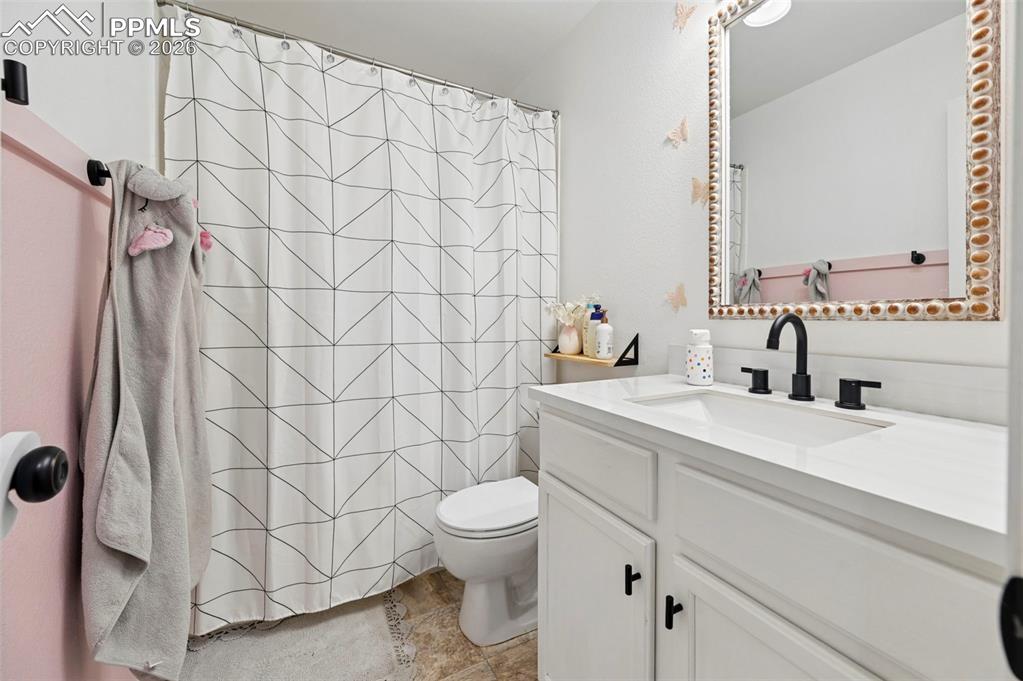 Image 31 of 45: Bathroom featuring a white vanity with a rectangular sink and a matte black