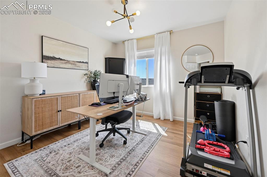 Image 32 of 45: Versatile interior space featuring light wood flooring, a window with white