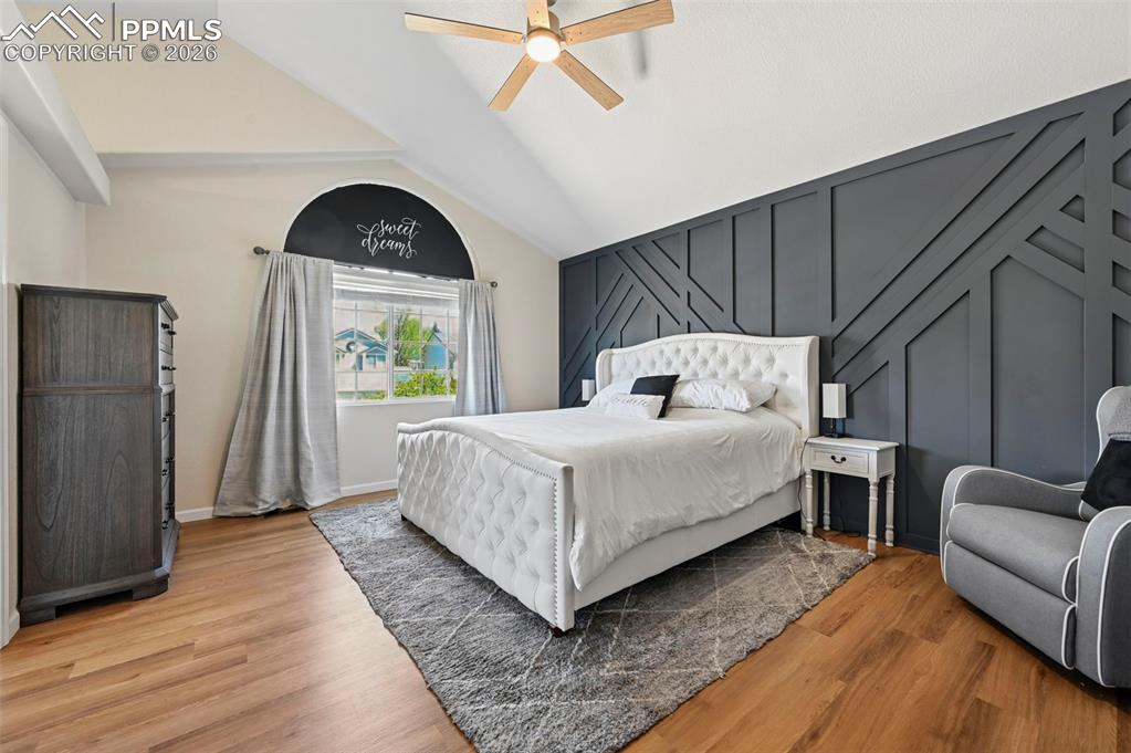 Image 36 of 45: This room features vaulted ceilings, wood flooring, and a decorative accent